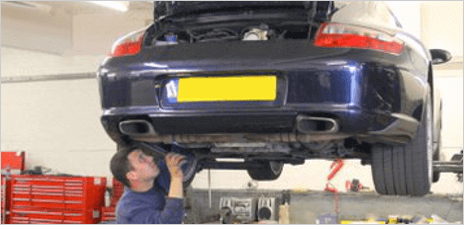 A mechanic working on a raised car