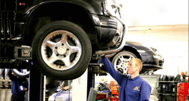 A mechanic looking at a car's tyres